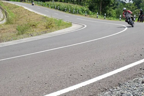 Mann mit klassischem Motorrad auf Bergstraße unterwegs — Stockfoto