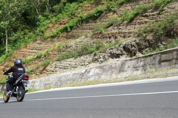 Man riding a classic motorcycle on highway of mountain — 스톡 사진