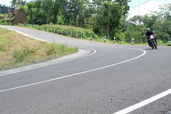 Man rijden een klassieke motorfiets op de snelweg van de berg — Stockfoto