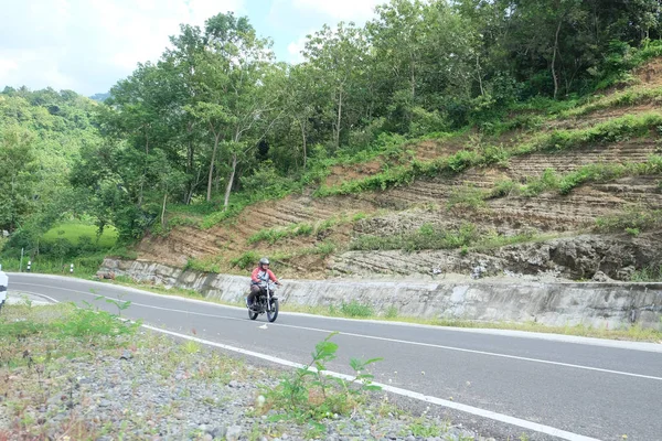Dağ yolunda klasik bir motosiklet süren adam. — Stok fotoğraf