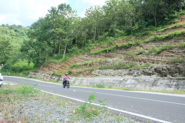 Mann mit klassischem Motorrad auf Bergstraße unterwegs — Stockfoto