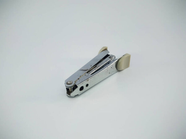 Stapler on white surface table. a device for fastening together sheets of paper with a staple or staples. A stapler is a mechanical device that joins pages of paper or similar material.