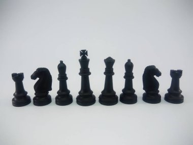 Black plastic king queen bishop knight rook line up chess piece isolated on a white background