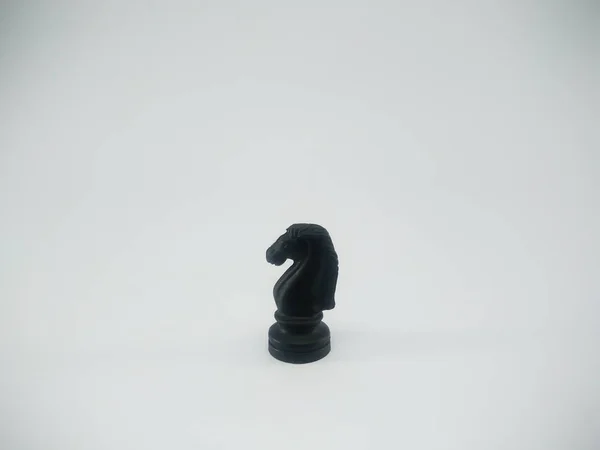 Black plastic knight chess piece isolated on a white background — ストック写真