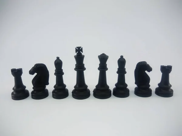 Black plastic king queen bishop knight rook line up chess piece isolated on a white background — ストック写真