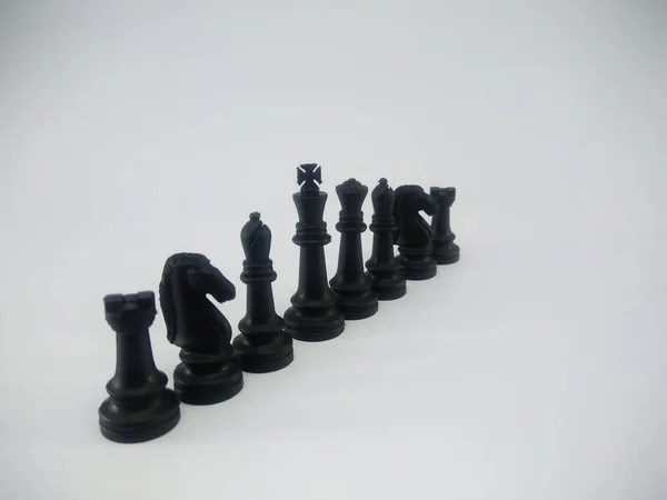 Black plastic king queen bishop knight rook line up chess piece isolated on a white background — ストック写真