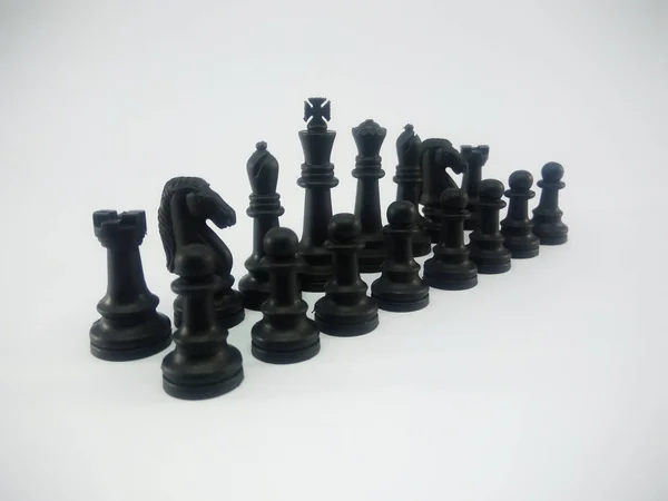 Черный пластиковый король королева епископ ладья ладья пешка выстроить шахматные фигуры изолированы на белом фоне — стоковое фото