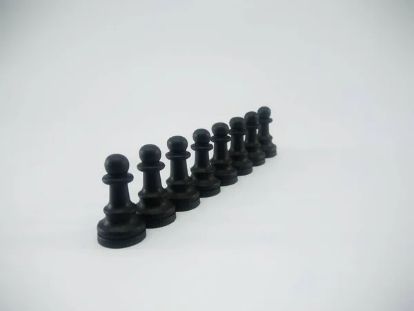 Black plastic line of pawn chess piece isolated on a white background — ストック写真
