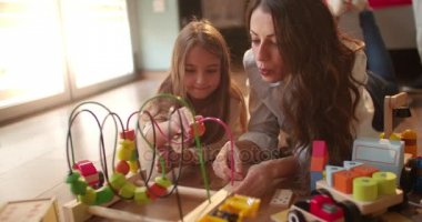 kızla oynayan esmer bebek bakıcısı