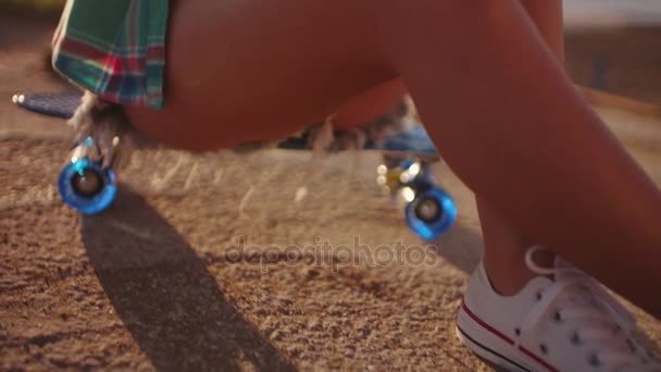 Девочка-подросток сидит на скейтборде — стоковое видео