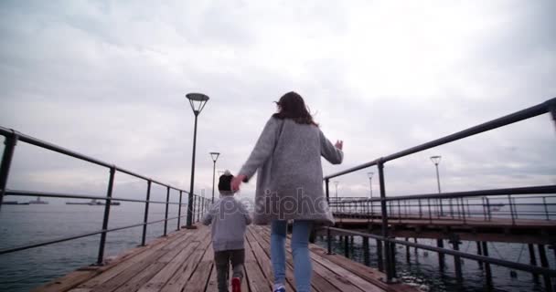 Junge rennt und spielt mit Mutter Flugzeuge — Stockvideo