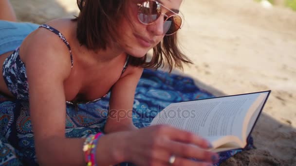 Mujer estudiando mientras está acostada en la playa — Vídeos de Stock