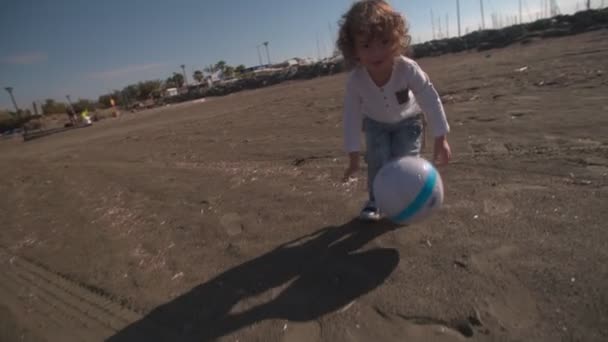 Blont lockigt barn spela fotboll — Stockvideo