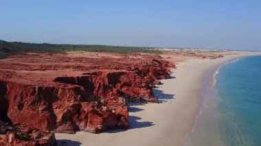 Plaj ve kayalar üzerinde uçan uçak