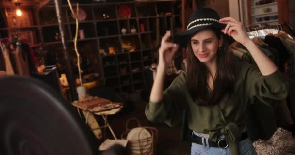 Mujer joven tratando de sombrero en tienda boutique — Vídeos de Stock