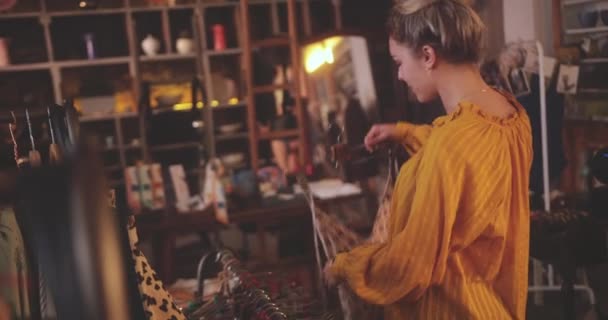 Mujer rubia comprando trajes de baño en una tienda boutique vintage — Vídeos de Stock