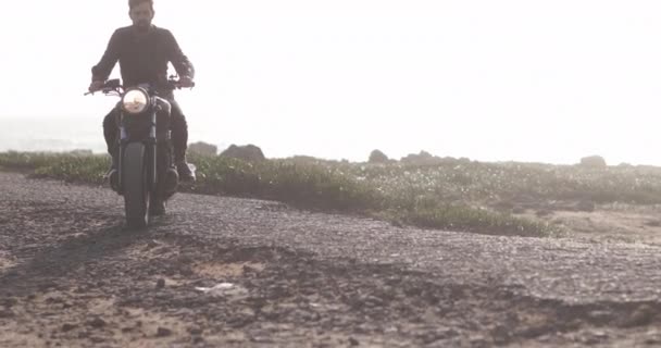 Красивый байкер на классическом мотоцикле у моря — стоковое видео
