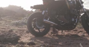 Motosikletli motorcunun yakına, deniz kenarına.