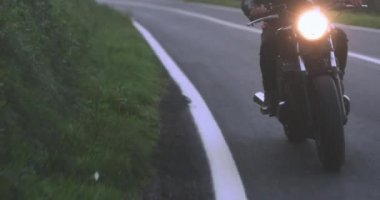 Motosikletli adam Country Road 'da klasik motosiklet sürüyor.