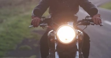 Motosikletli adam Country Road 'da klasik motosiklet sürüyor.