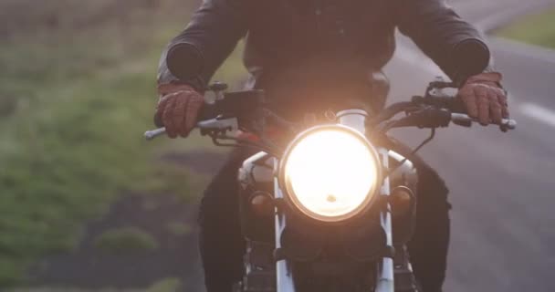 Hombre motociclista montando en motocicleta clásica en carretera de campo — Vídeo de stock