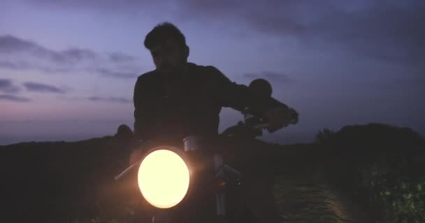 Hombre con chaqueta de cuero cabalgando en motocicleta clásica — Vídeos de Stock
