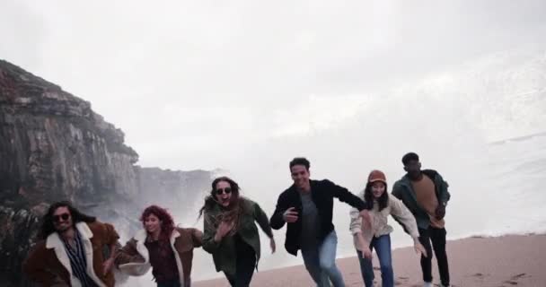 Multietnická skupina přátel utíkající z vlny na pláži — Stock video