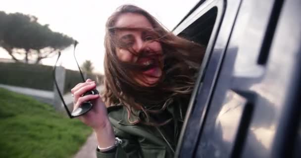 밴 창문에서 몸을 기울이고 있는 매력적 인 젊은 여자 — 비디오