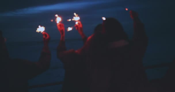 Close up de amigos segurando sparklers à noite — Vídeo de Stock