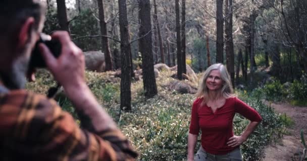 Senior man neemt foto van senior vrouw op bos — Stockvideo