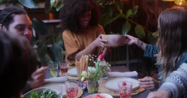 Çok ırklı arkadaşlar ve avluda yemek dağıtan çiftler.