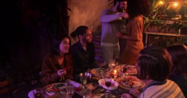 Avluda yemek yerken çok ırklı dostlara katılan beyaz bir adam