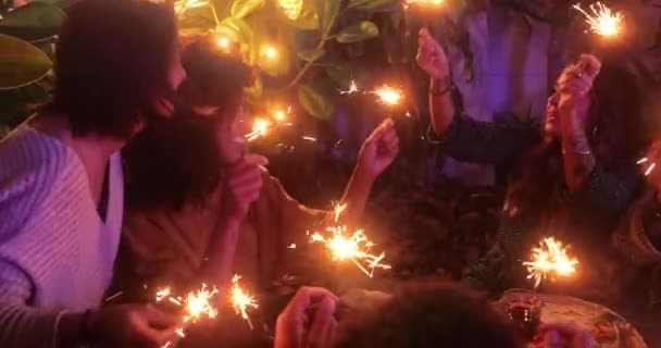 Amigos multiétnicos cantando celebrando comida de cumpleaños con bengalas — Vídeos de Stock