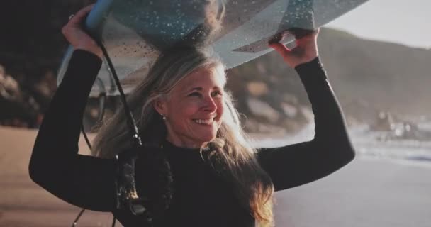 Закрыть пожилую женщину, бегущую с доской для серфинга на пляже — стоковое видео