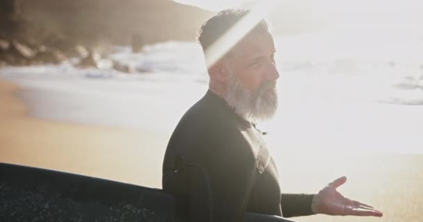 Cerca de hombre mayor hablando sosteniendo tabla de surf en la playa — Vídeos de Stock