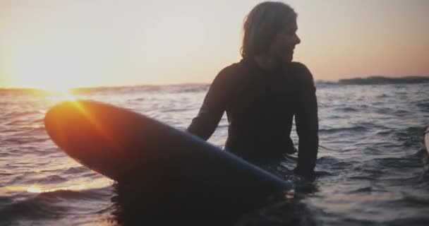 Närbild senior kvinna surfa i vattnet vid solnedgången — Stockvideo