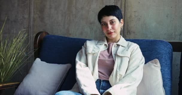 Close up portrait of young caucasian woman sitting on sofa — Stock Video