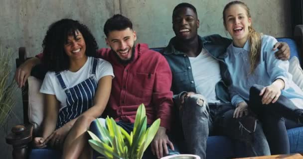 Multi-étnicos jóvenes amigos abrazando y sonriendo sentado en el sofá — Vídeo de stock