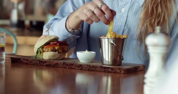 Närbild hamburgare och blond kvinna doppa pommes frites på majonnäs — Stockvideo