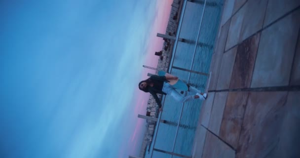 Rotating video van jonge Aziatische vrouw met skateboard op pier — Stockvideo