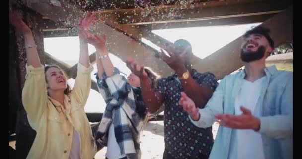 Close up multi-ethnic young friends throwing colorful confetti by pier — Stock Video