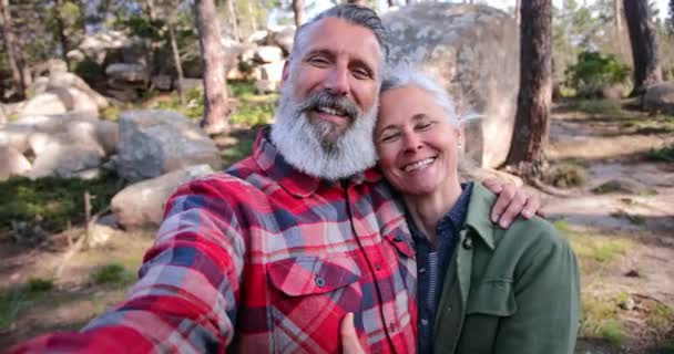 Cerca de pareja de ancianos abrazándose tomando selfie en el bosque — Vídeo de stock