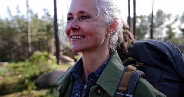 Закройте пожилую красивую женщину, которая наслаждается природой в лесу — стоковое видео