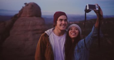 Çok ırklı sevgili ve kız arkadaş dağ yürüyüşü macerasında selfie çekiyorlar.