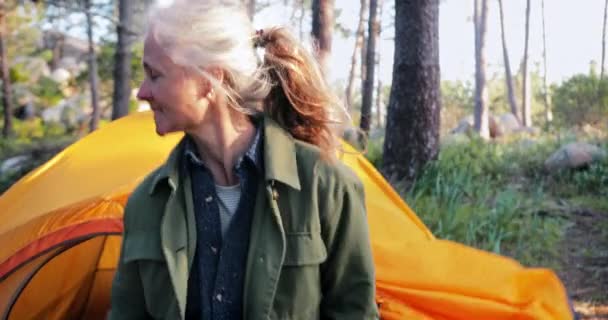 Закройте пожилую пару, выходящую из палатки в лесу — стоковое видео