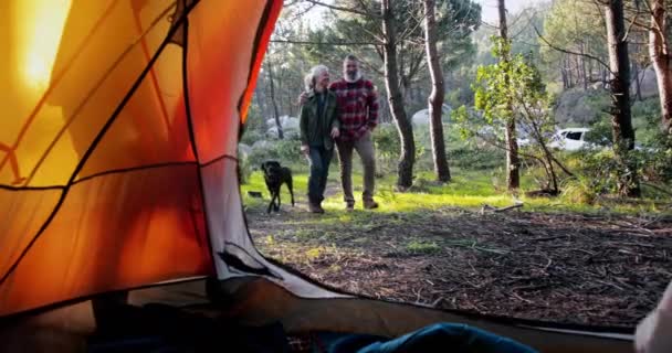 Закройте пожилую пару с собакой, заходящей в палатку — стоковое видео