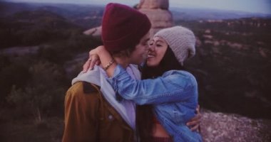 Hippi çok ırklı çift dağ zirvesinde öpüşüyor.