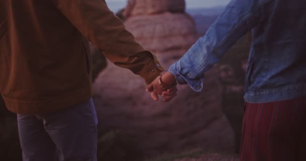 Primer plano de la pareja cogida de la mano mientras está de pie en la cima de la montaña — Vídeo de stock