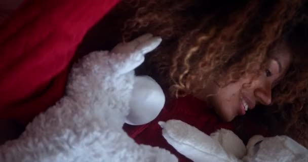 Close up black woman lying on sofa holding plush toy — Stock Video
