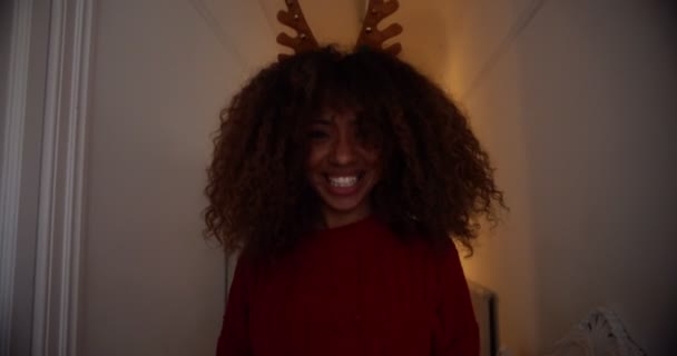 Mujer negra vistiendo diadema de cuernos de reno, agitando su cabello — Vídeo de stock